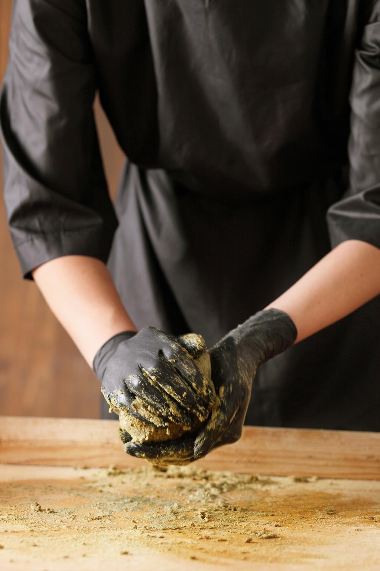 Chef demonstrating technique over wooden table