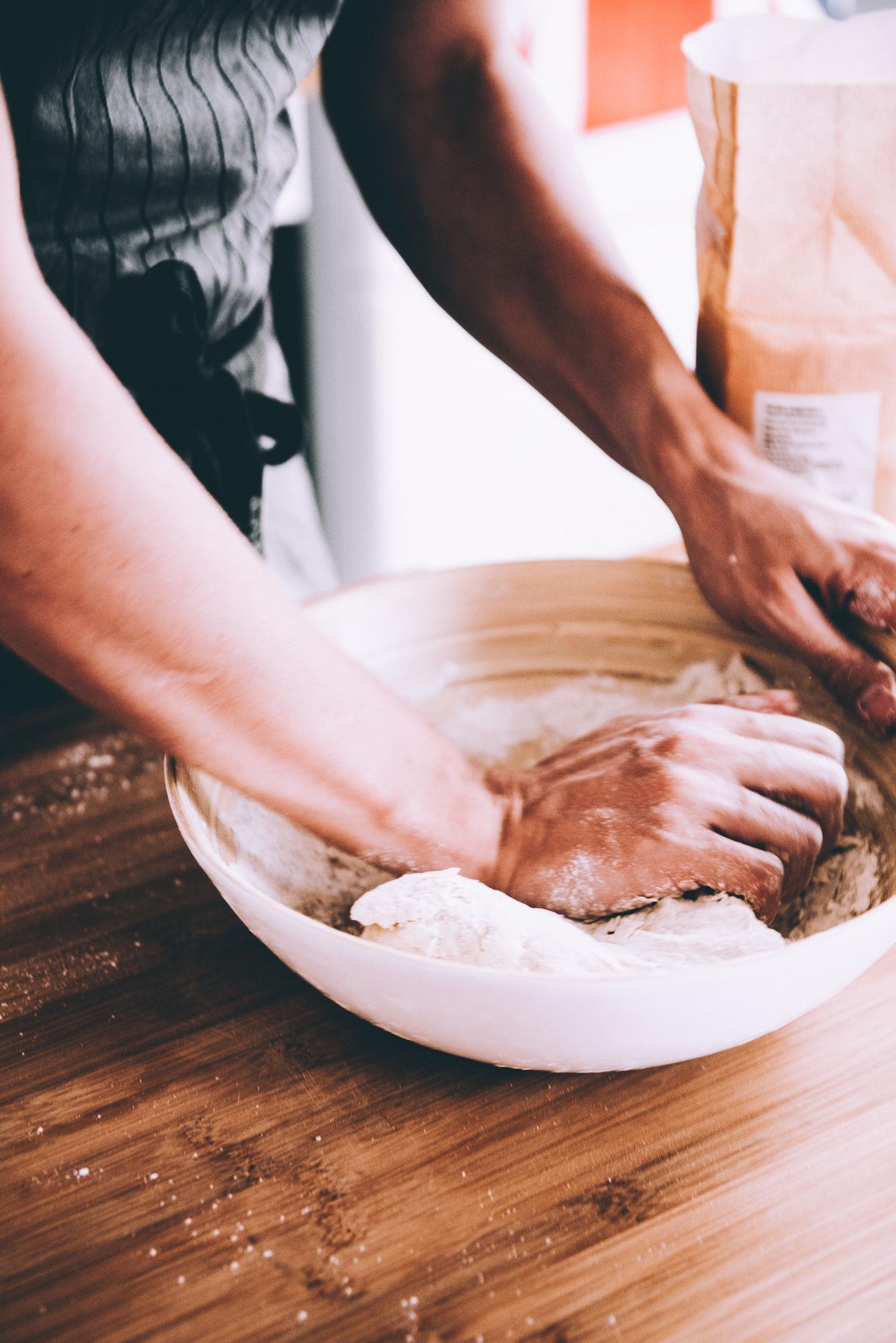 Participant kneading dough in hands-on class